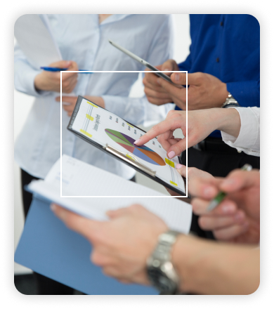 Hands pointing to a pie-chart on a tablet during a team discussion