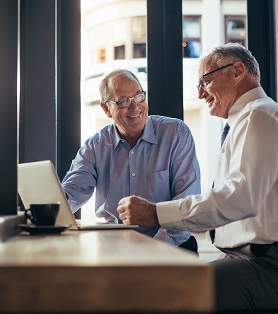 Two senior businessmen working together in modern cafe