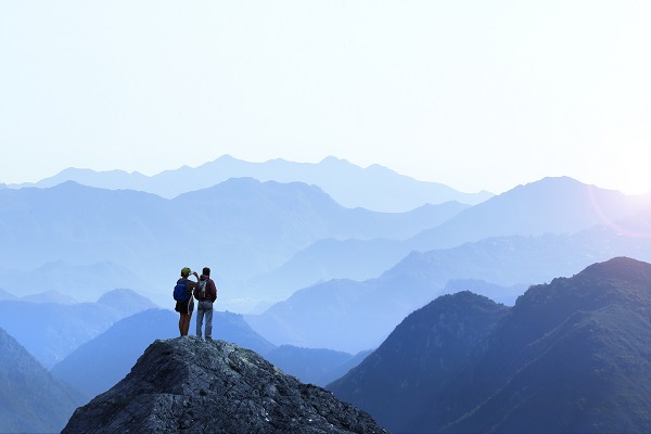 Two hikers on a mountain summit with scenic view