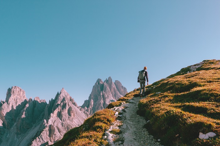 Man hiking alone on the edge of the rock and looking towards the horizon