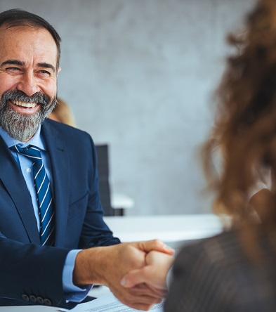 Smiling businessman shaking hands with a colleague in the office