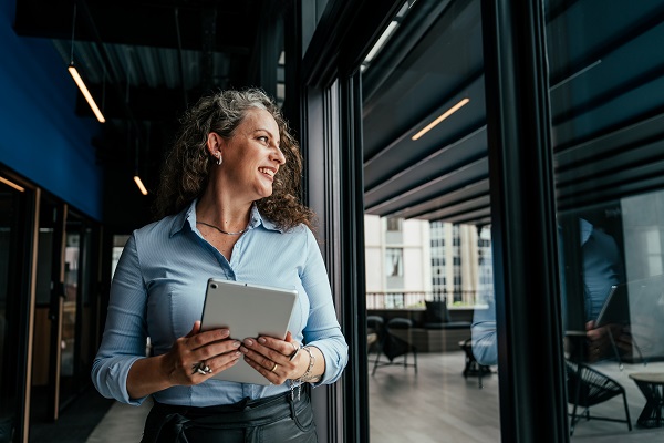 Businesswoman standing in a modern office holding a tablet