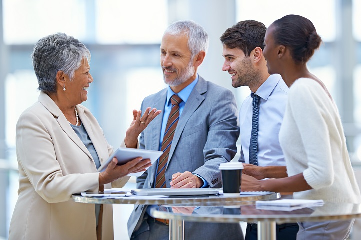 Smiling professionals having a discussion around a table