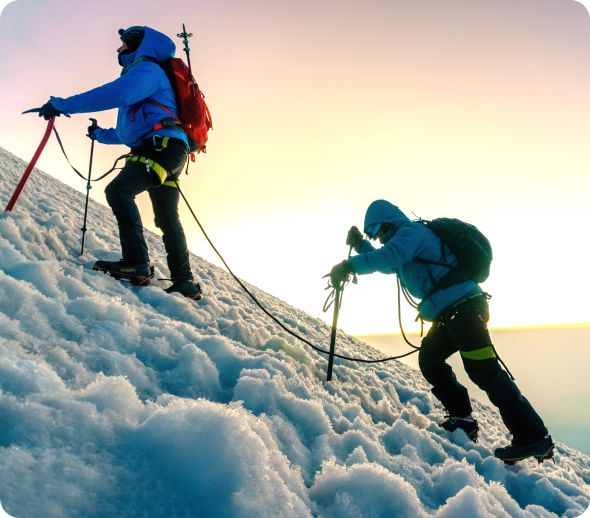 Two hikers climbing a snowy slope